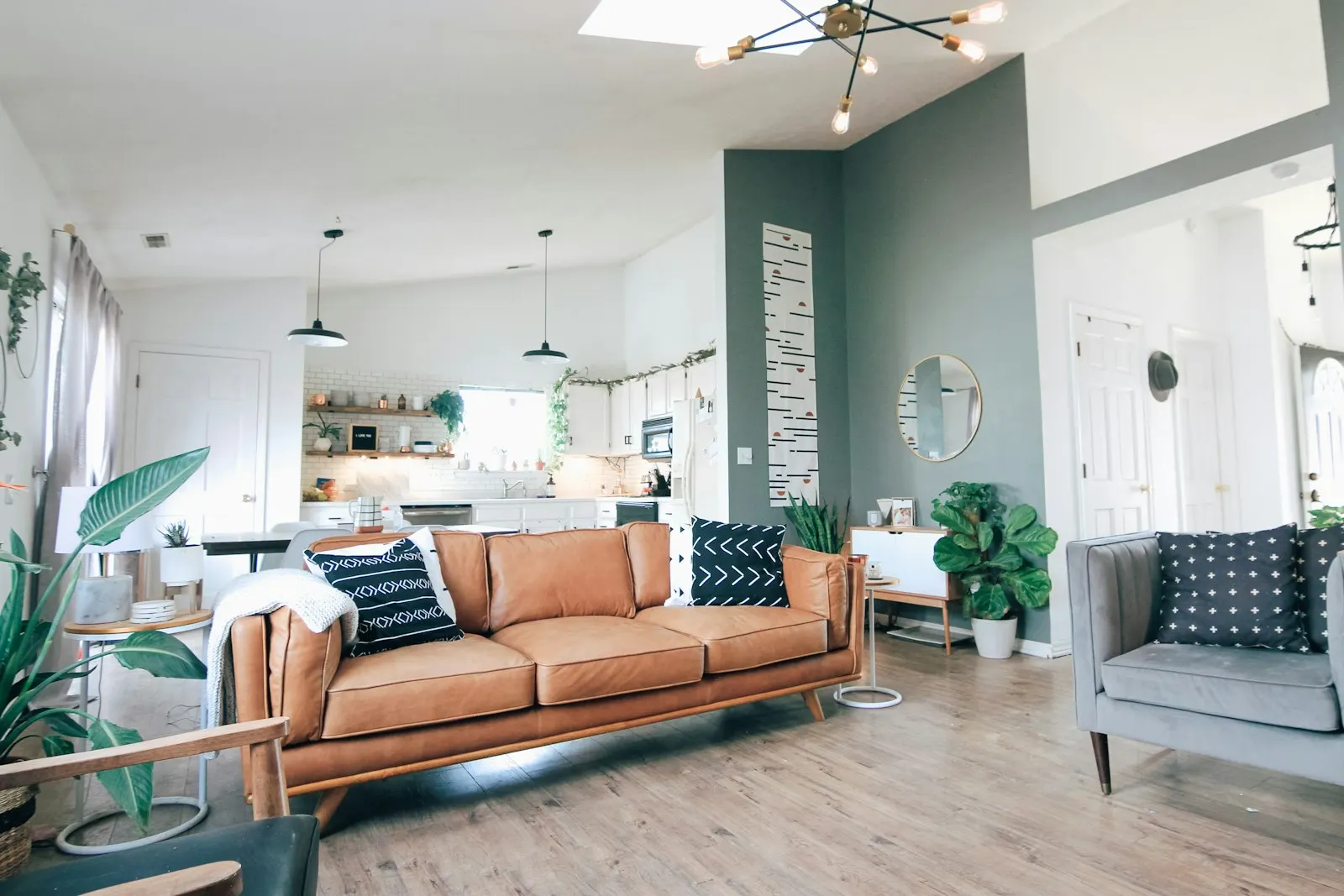 Bright open plan living room with a leather sofa and plants